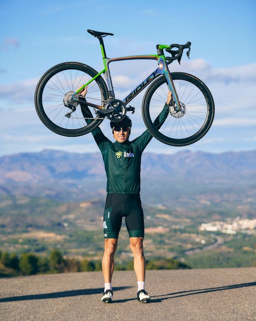 Cyclist Holding Road Bike in Raised Arms
