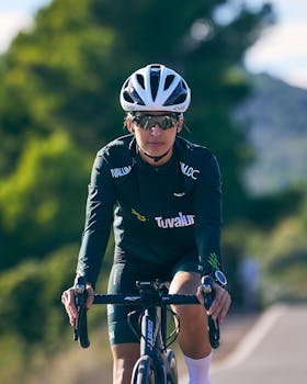 Portrait of a female cyclist wearing helmet and sunglasses during training on a sunny day.