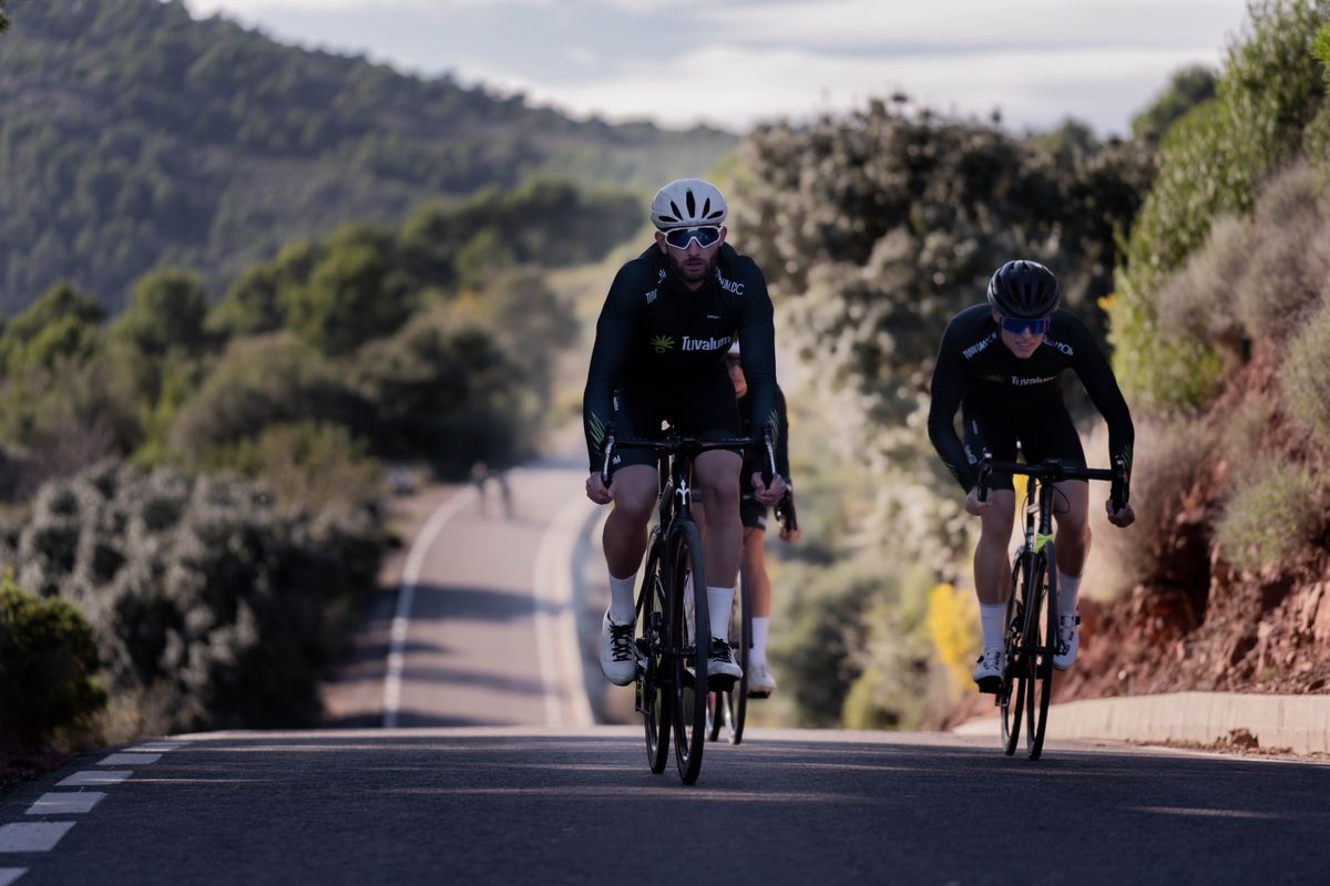 Cyclists climbing a hill together on a road bike ride