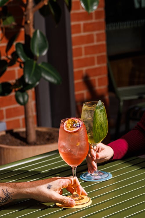 Man and Woman Hands Holding Glasses of Cocktails