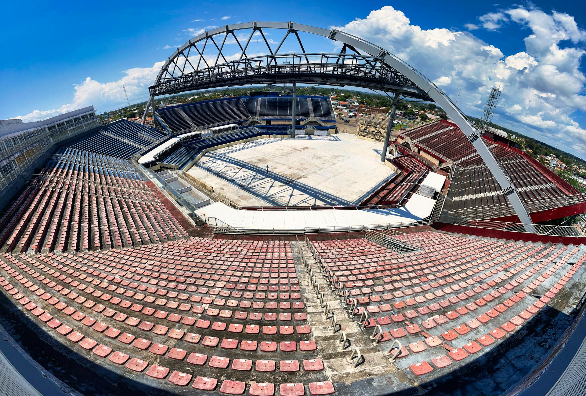 High-angle fisheye view of the empty Bumbodromo arena in Parintins, Brazil, showcasing modern architecture and summer skies.