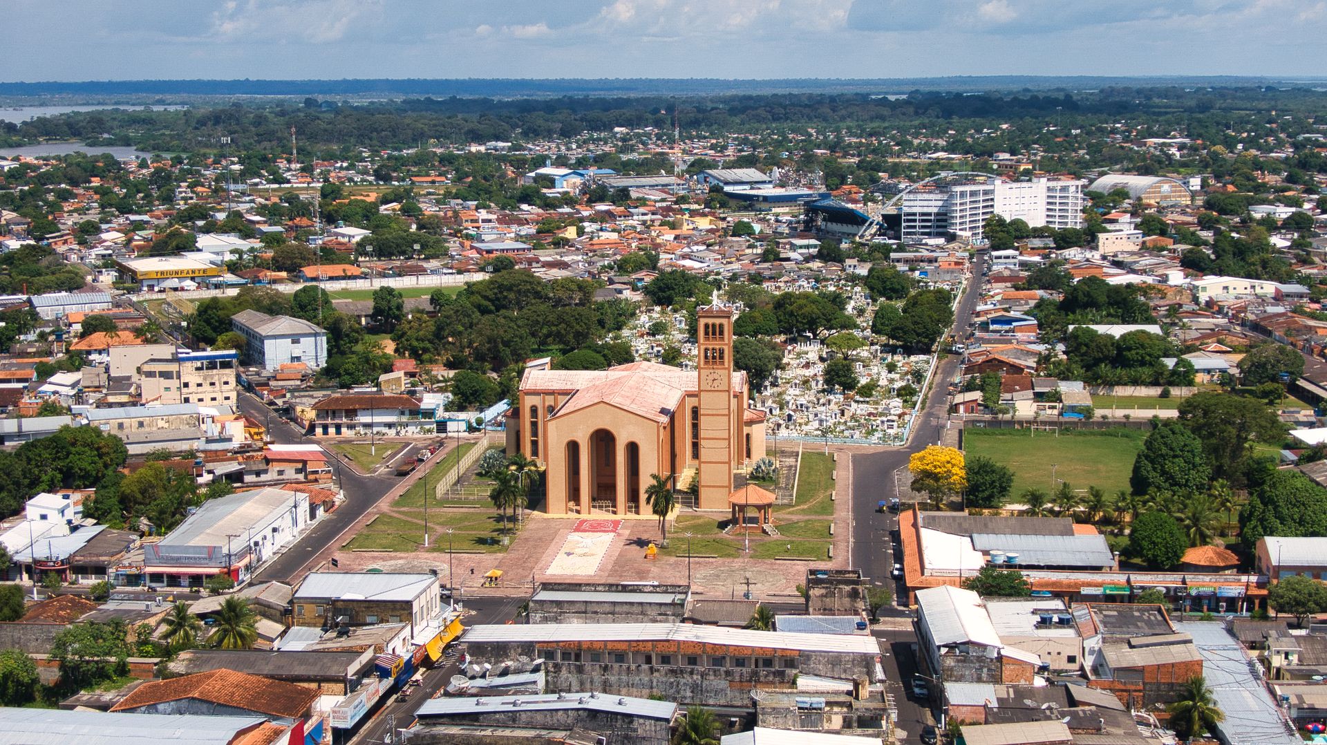 Aerial shot of Parintins, Brazil highlighting the prominent church in a bustling urban landscape.