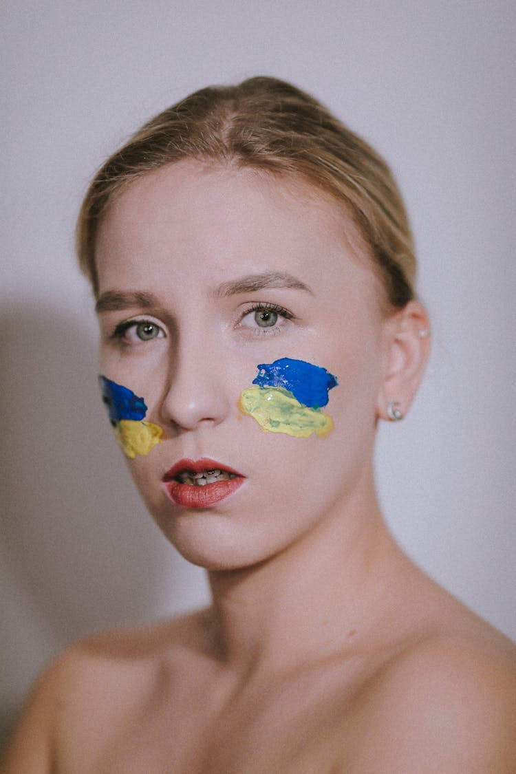 Young Woman With National Colors Of Ukraine On Her Face 