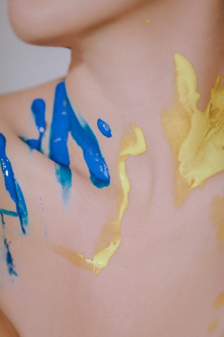 Blue And Yellow Paint On Woman Neck