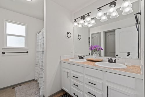 Free A chic bathroom features a double vanity, decorative lighting, and elegant fixtures. Stock Photo