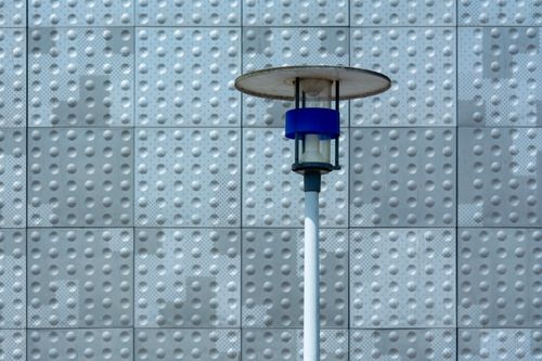 Free A modern solar lamp stands in front of a textured wall, showcasing urban design. Stock Photo