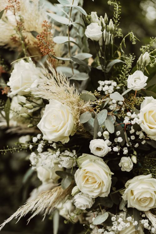 Free A lush arrangement of white roses and green foliage, perfect for weddings or elegant decor. Stock Photo