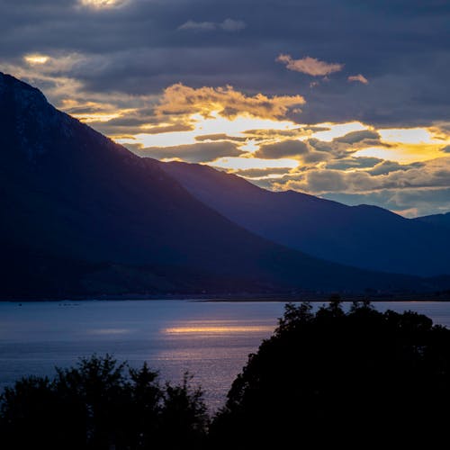 Clouds over Lake in Mountains at Sunset