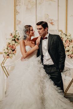 Sophisticated wedding portrait featuring a bride and groom in formal attire, posing elegantly.