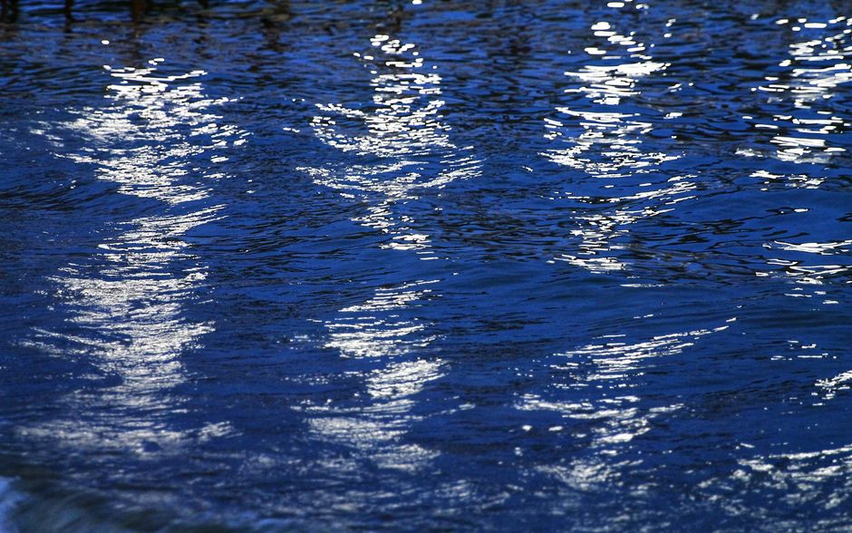 A calm lake surface reflecting soft light during dusk, creating a serene atmosphere.
