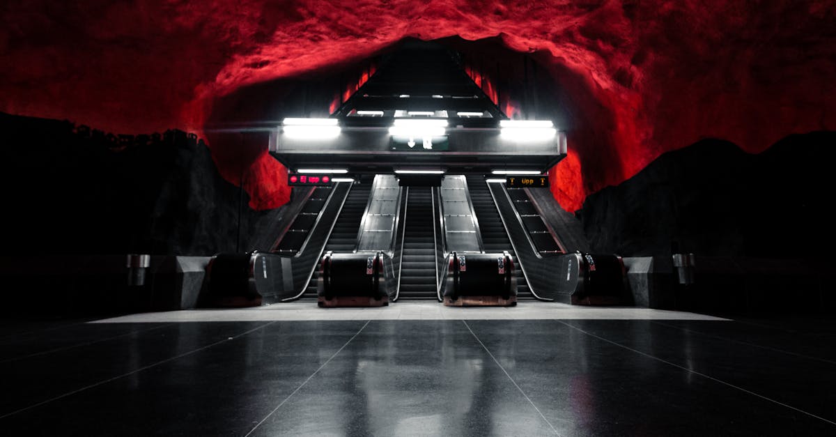 Captivating image of lit escalators at Solna Centrum Station, Stockholm with red cave-like ceiling.