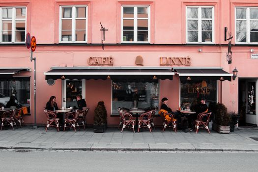 Elegant outdoor seating at Café Linné with patrons enjoying the street view in Uppsala.