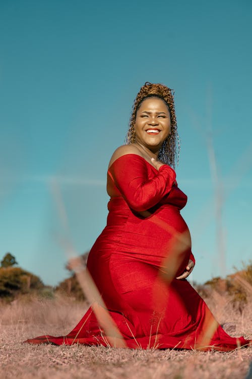 Smiling Pregnant Woman in Elegant Red Dress