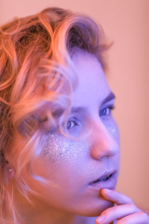 Free Elegant close-up of a woman with glitter makeup and soft lighting. Stock Photo