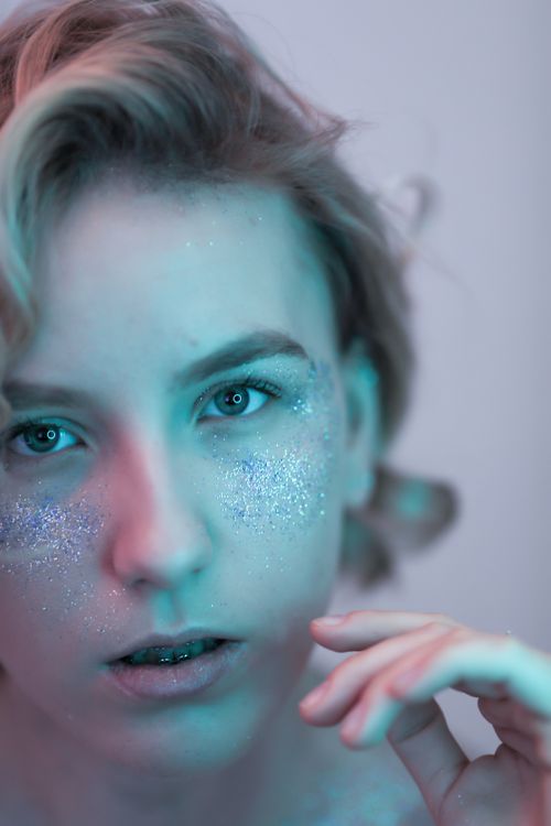 Free Close-up portrait of a woman with glitter makeup, soft focus and pastel tones. Stock Photo