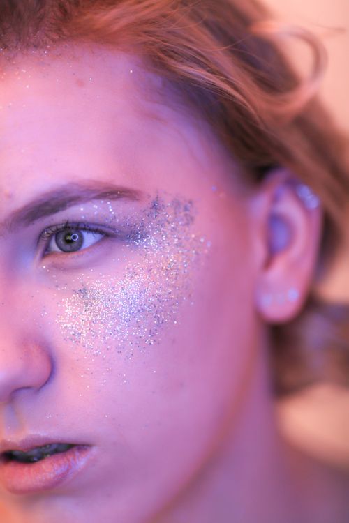 Free Close-up portrait of a young woman with glamorous glitter makeup on her face. Stock Photo