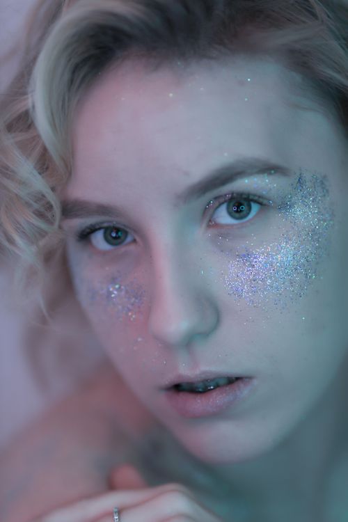 Free Close-up portrait of a woman with glitter makeup and blonde hair, highlighting artistic expression. Stock Photo
