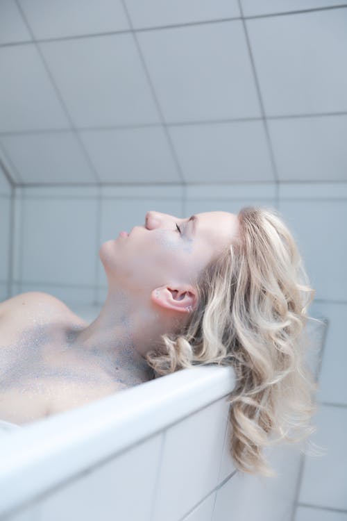 Blond with Glitter on Body Lying in Bathtub