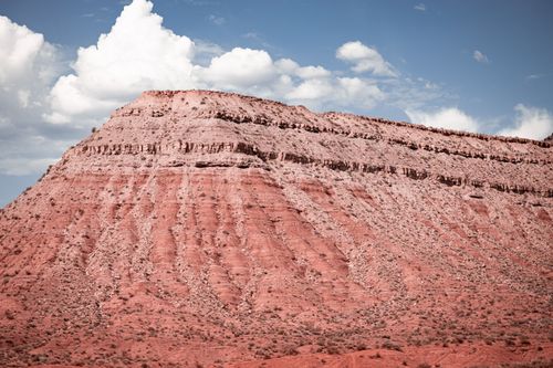 Free Stunning view of a red rock formation with cloud-filled sky, showcasing geological beauty. Stock Photo