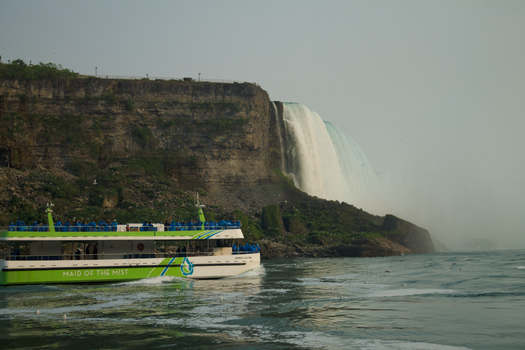 Passenger ship Maid of the Mist approaching the breathtaking Niagara Falls on a misty day.