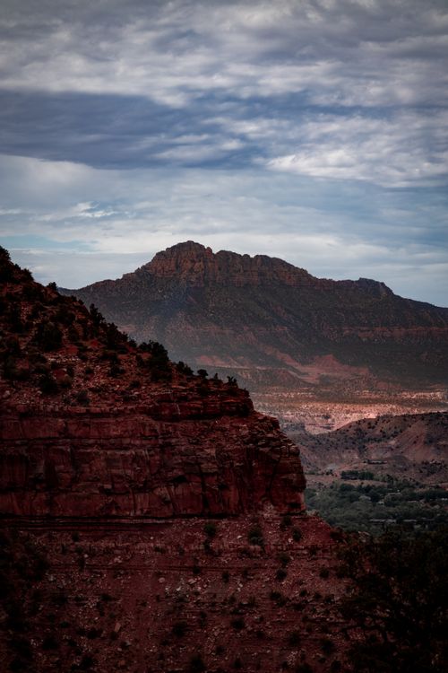 Free Stunning canyon landscape with towering cliffs under a dramatic cloudy sky, perfect for nature and travel themes. Stock Photo