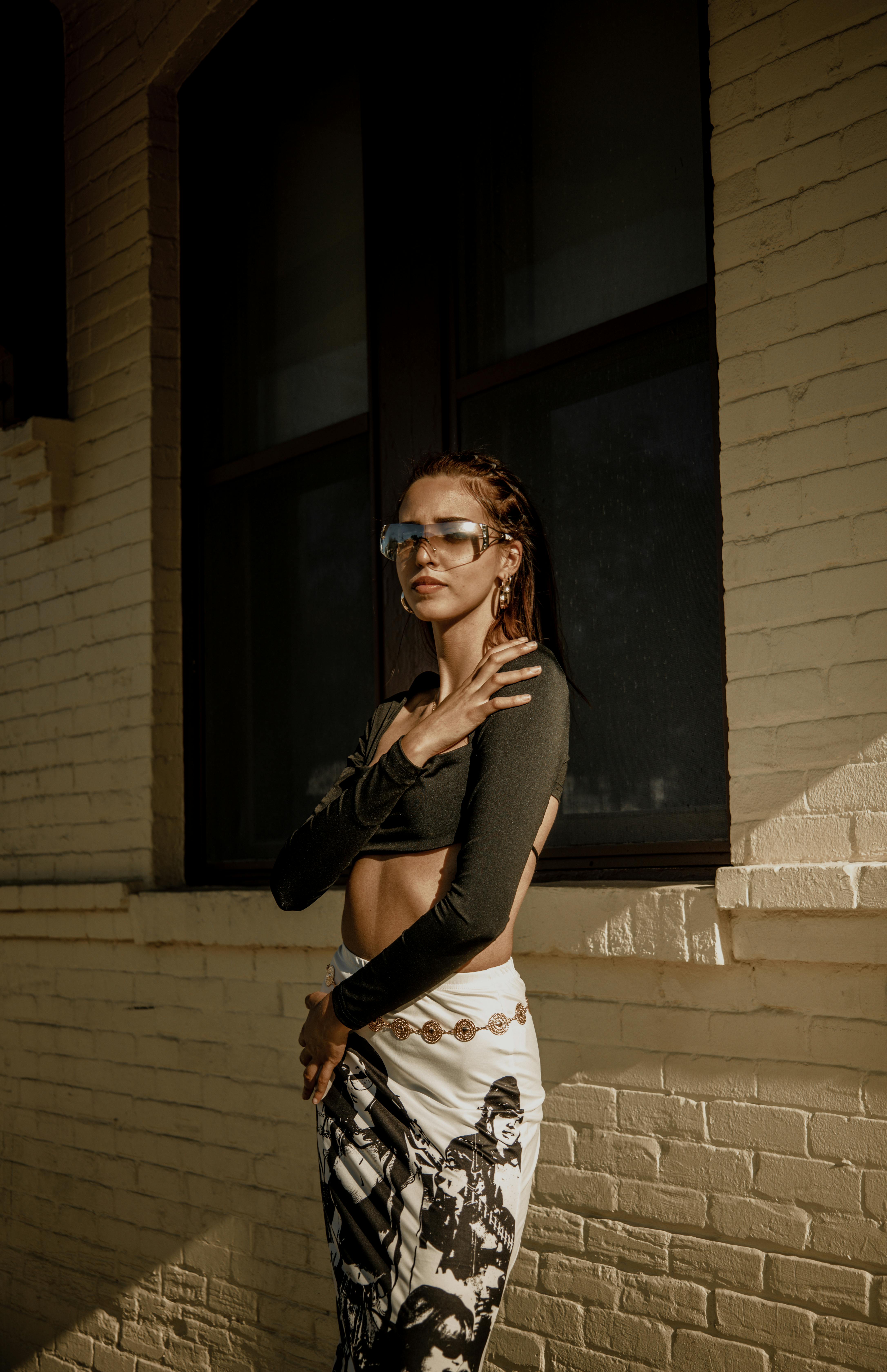 a woman in a crop top and leggings poses for a photo