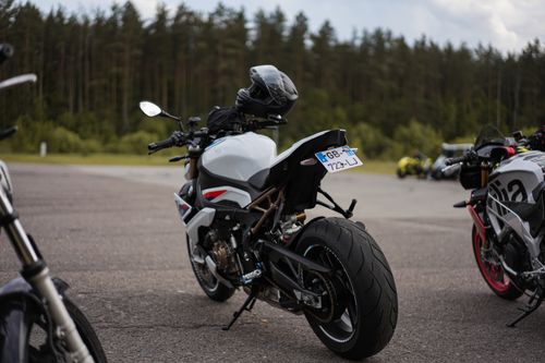 Free Close-up view of a parked sport motorcycle with helmet under cloudy skies. Stock Photo