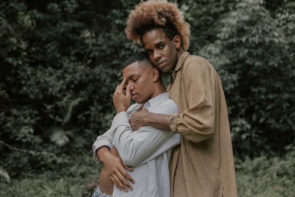 Two adults sharing an intimate embrace outdoors, depicting love and connection.