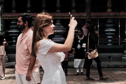 Young Woman Taking a Picture while Sightseeing a Temple 