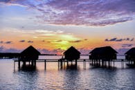 海边充满活力的日落天空映衬着水上平房的轮廓