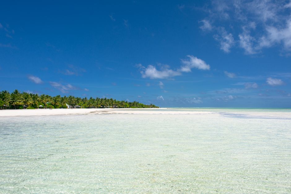 A stunning tropical beach with crystal clear waters and lush greenery.