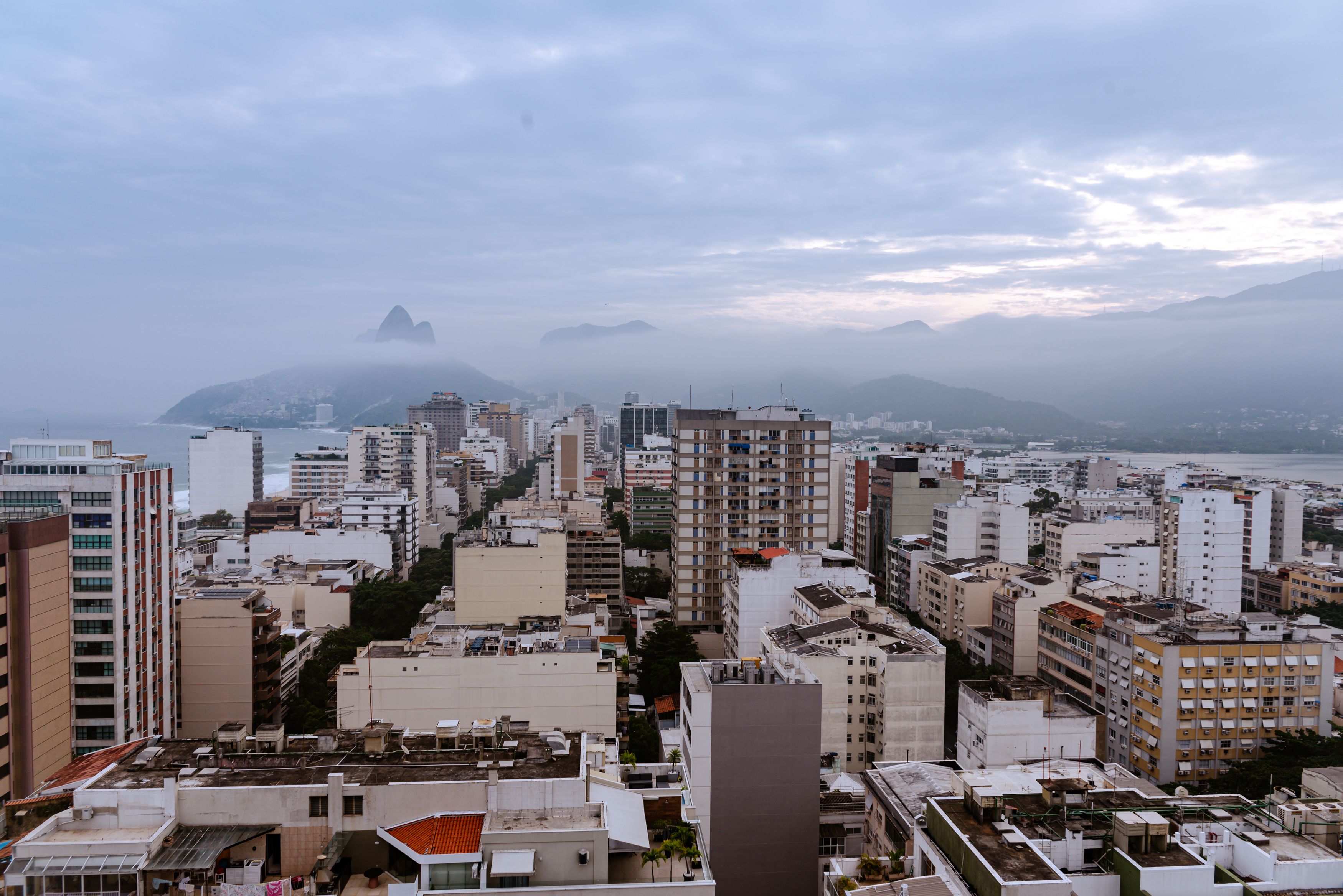 Unbeatable Helicopter Tour in Rio de Janeiro - 25 Minutes Review: Soaring Over the Marvelous City Review 2026 - Aerial cityscape of Rio de Janeiro with misty mountains and coastal view during overcast weather.
