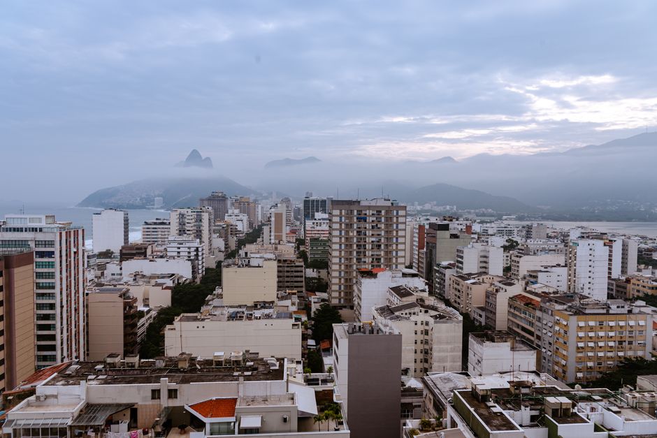 Unbeatable Helicopter Tour in Rio de Janeiro - 25 Minutes Review: Soaring Over the Marvelous City Review 2026 - Aerial cityscape of Rio de Janeiro with misty mountains and coastal view during overcast weather.