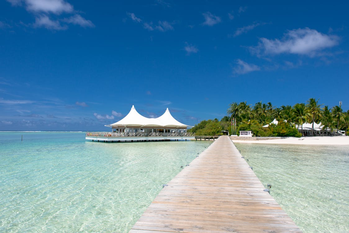 Beach Dock Near Hut Under Blue Skies