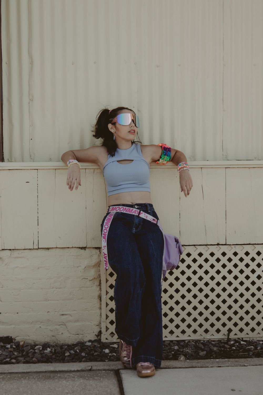 A woman leaning against a wall wearing a blue top and jeans · Free ...