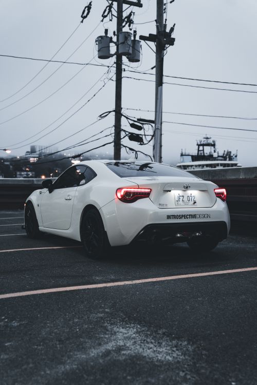 Free A white Toyota GT86 parked in an urban setting, showcasing its sleek design and modern style. Stock Photo