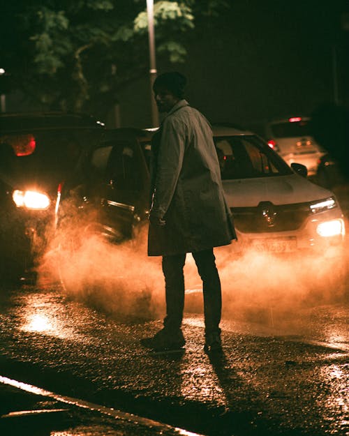 Man Standing on Street after Rain at Night