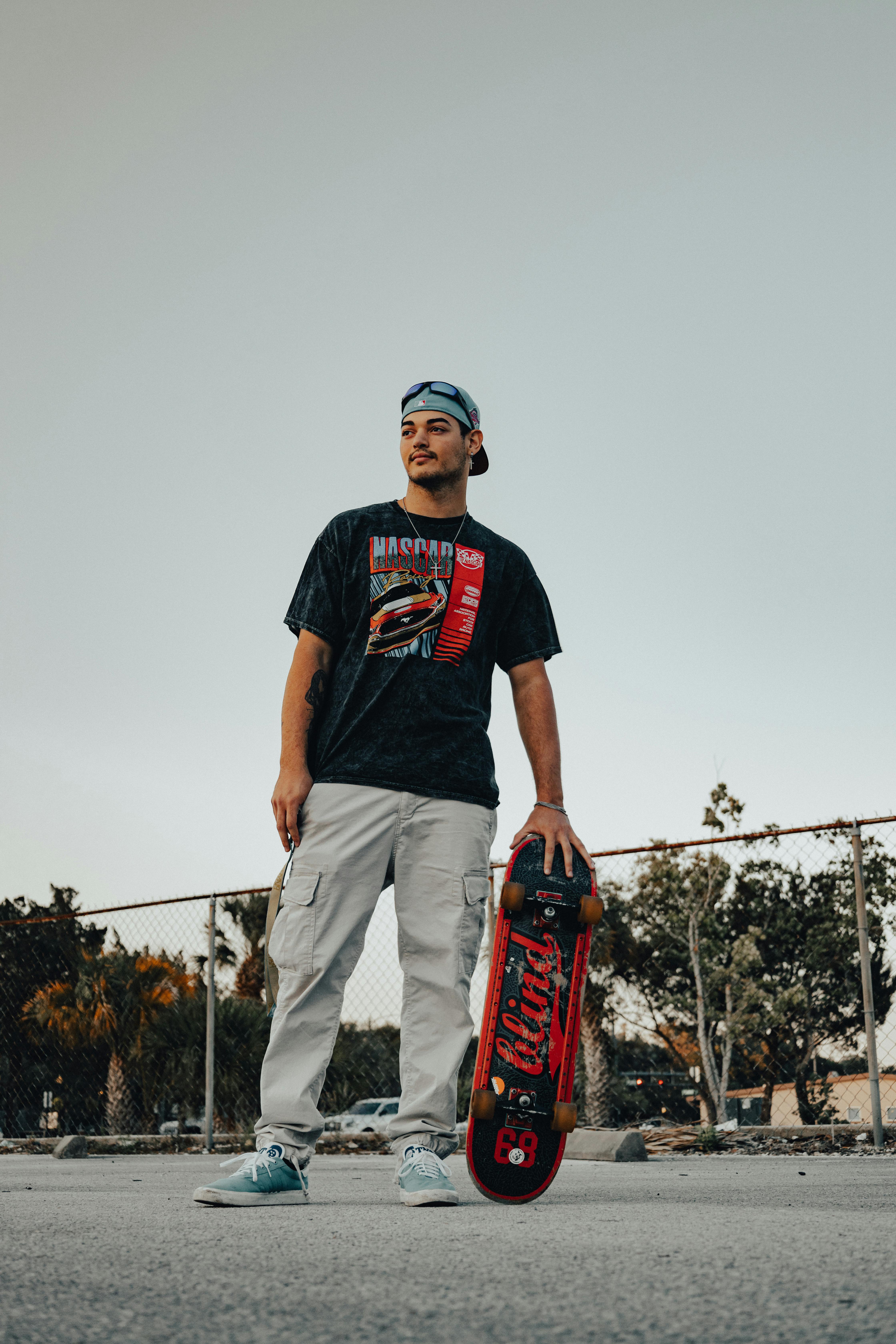 a young man holding a skateboard in his hand