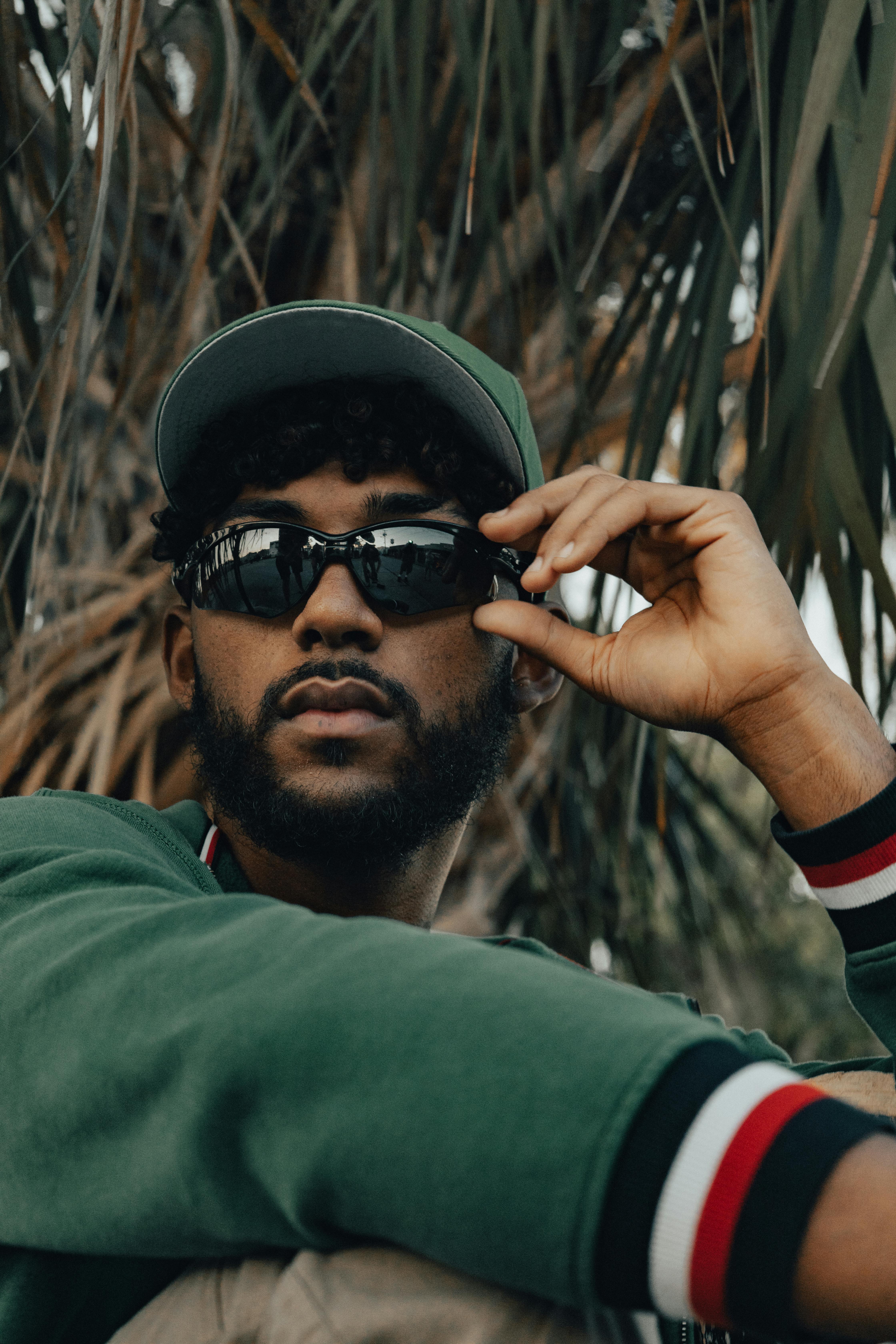 a man wearing sunglasses and a green sweater