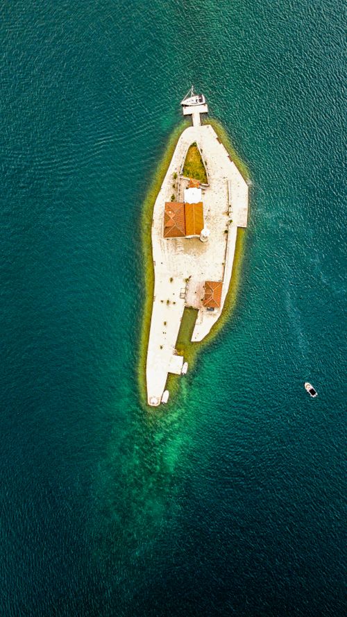 Free Stunning aerial shot of a small island resort surrounded by deep blue ocean waters. Stock Photo
