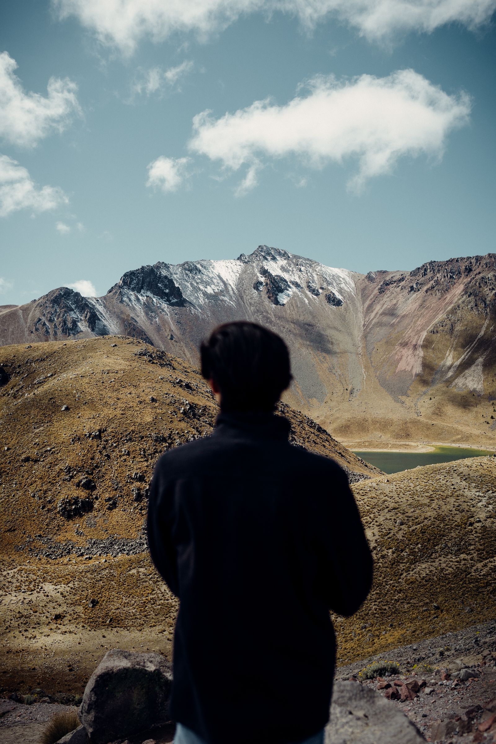 Traveller looking out over a misty mountain range from a ridge