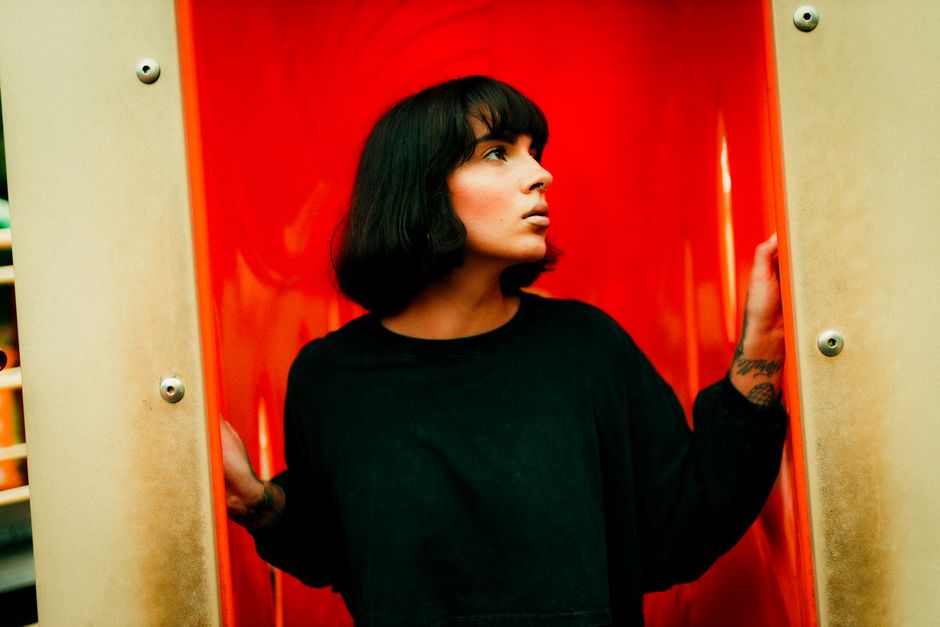 Creative portrait of a woman with short hair against a vibrant red background, shot in Atlanta.
