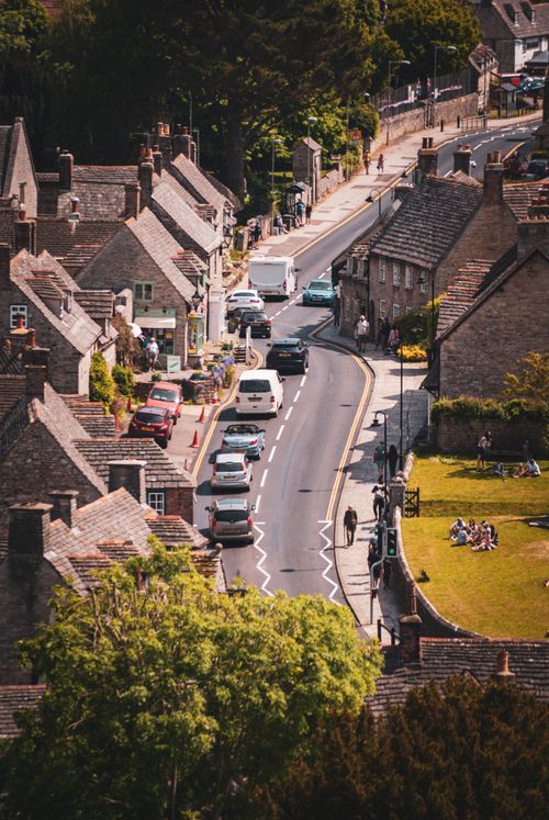 Free A picturesque aerial view of Corfe Castle village showcasing old stone houses and streets in England. Stock Photo