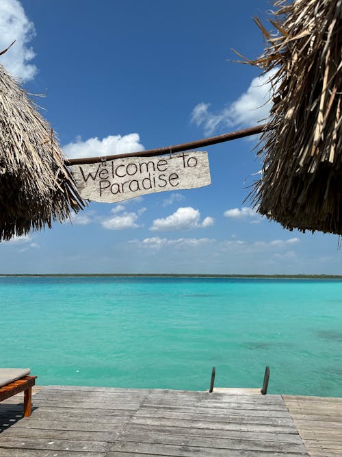 A Sign Saying Welcome to Paradise Hanging on the Shore 