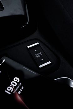 Elegant car console featuring a drive mode selector and smartphone. Luxury automotive technology.