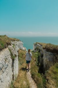 A footpath between chalk cliffs above the sea, photo by Trace Constant on Pexels
