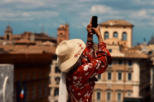 Woman in Hat and Sundress Taking Pictures with Smartphone