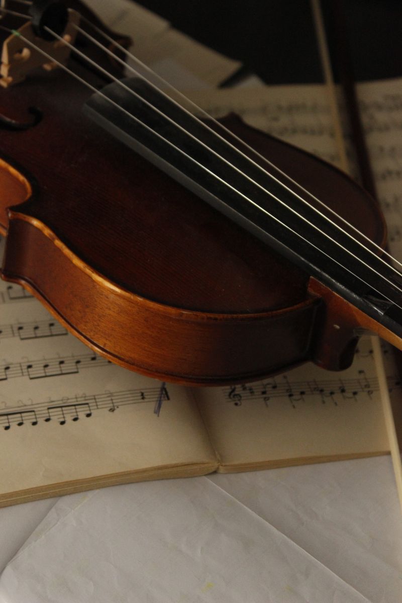 Violin resting on sheet music in warm light