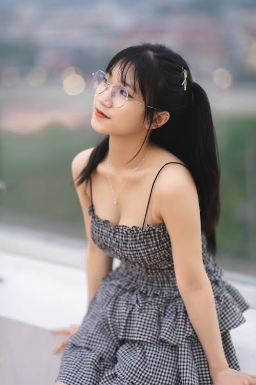 Young Brunette with Bangs in a Dress and Eyeglasses