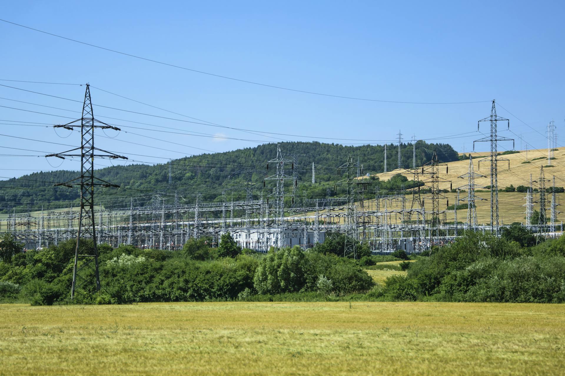 Electric transmission towers against a rural landscape, showcasing energy infrastructure.